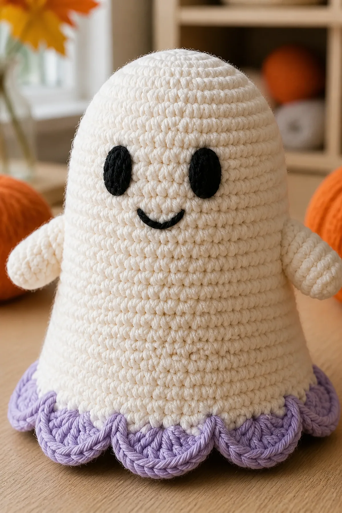 Close-up of embroidered ghost face, integrated arm, cream stitches, and lavender scallops