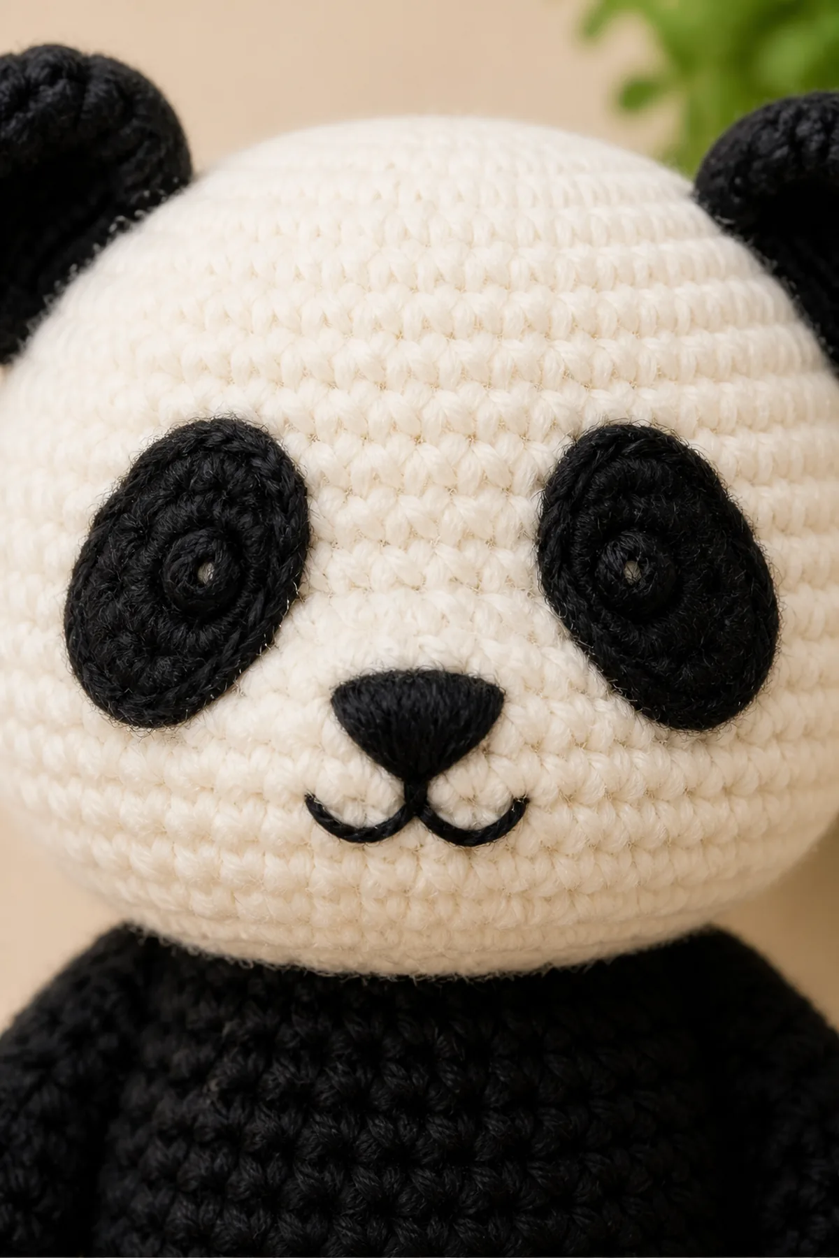 Embroidered panda eye patches, nose, mouth, and crochet ear detail