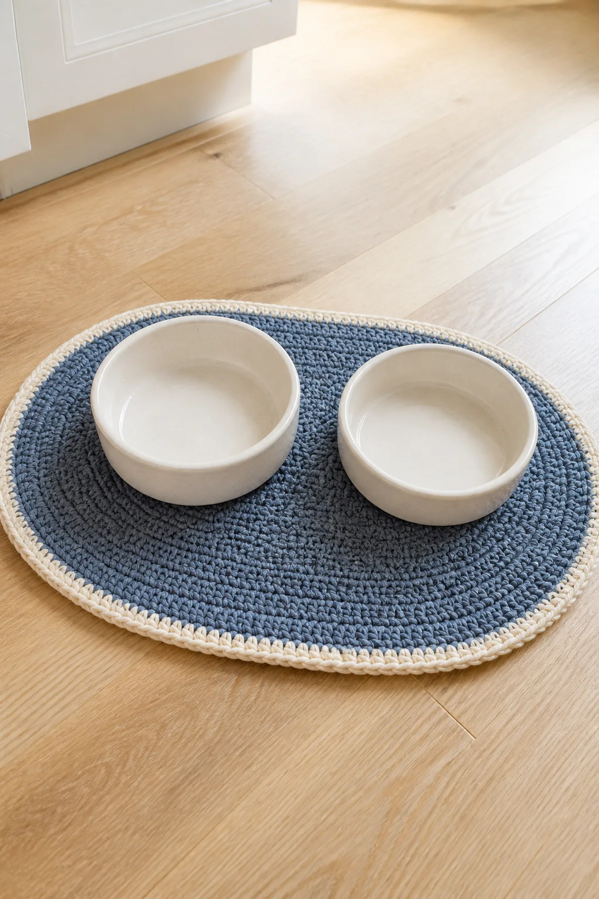 Finished slate blue oval pet bowl mat with cream border