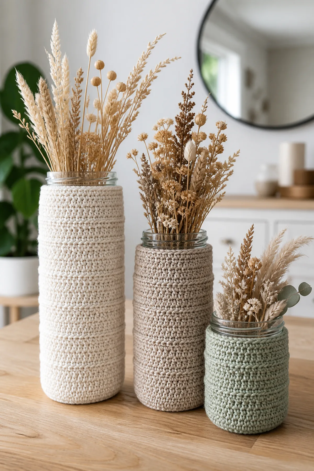 Cream, oatmeal, and sage textured crochet covers on three glass jar vases